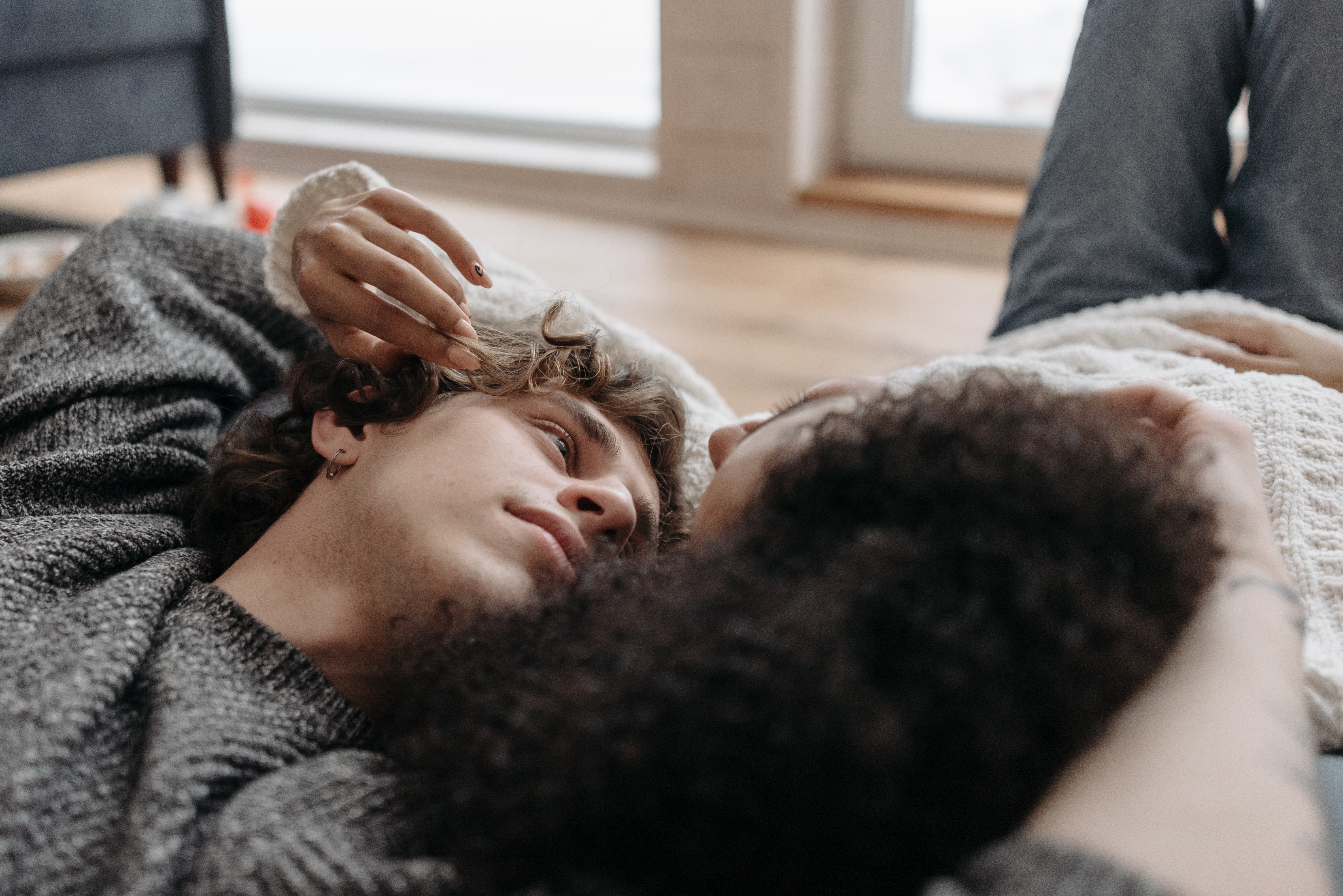 A couple lying together, heads close, in quiet conversation